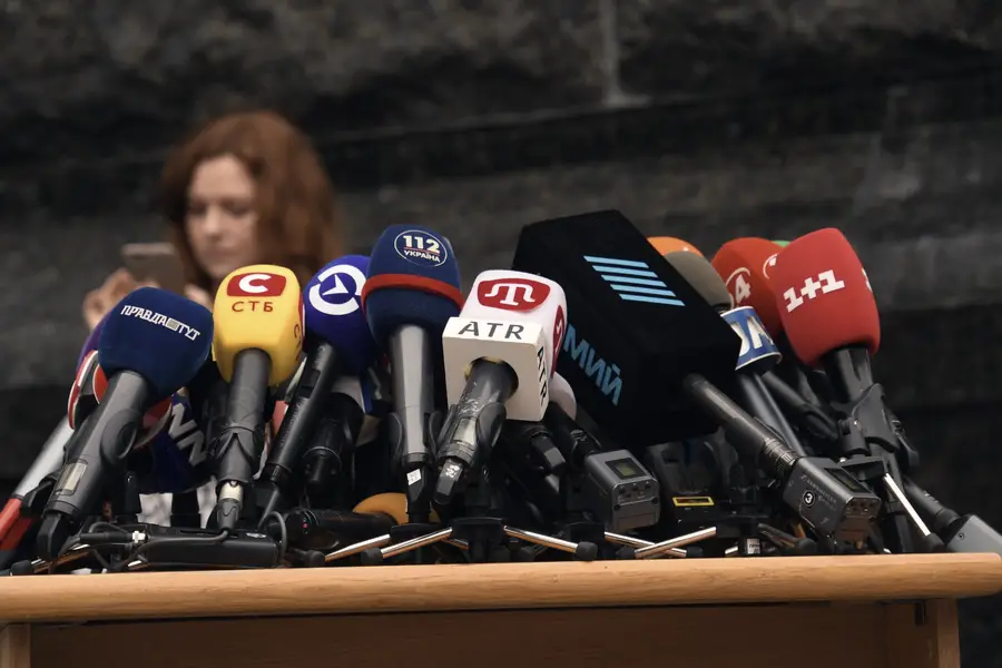 A bank of broadcast microphones set up for a press conference