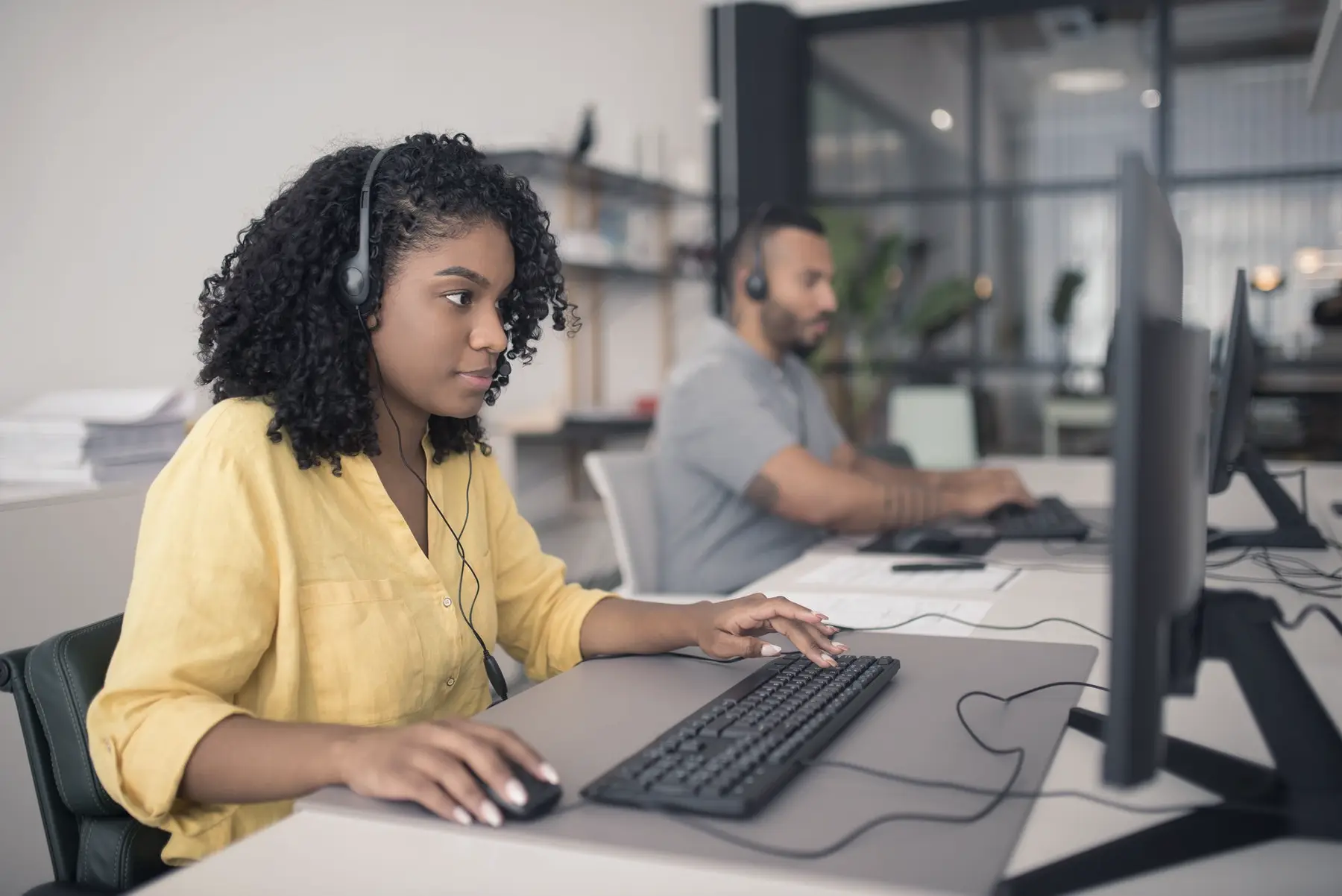 A contact centre agent working at a desk wearing a headset