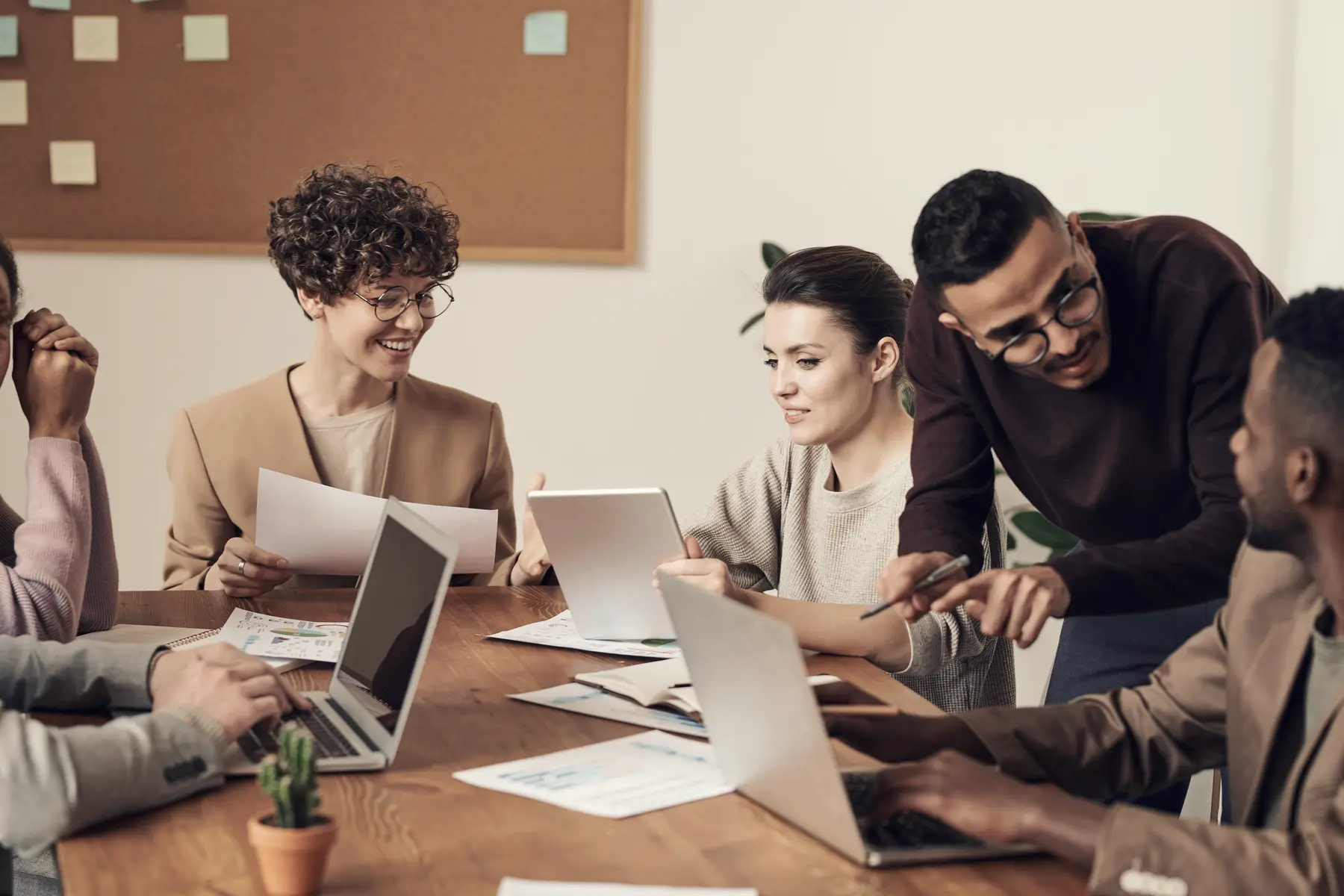 A group working together around a table with laptops and documents