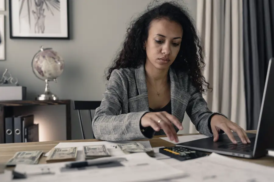 A finance professional working through figures at a desk